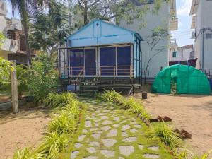 una casa blu con una tenda verde su una strada di Reho Resort 