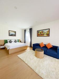 1 dormitorio con 1 cama y 1 sofá azul en Mimi Coastar Villa, en Ho Tram