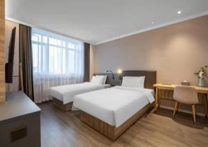 En eller flere senge i et værelse på Hanting Hotel Jinan Gangxi Road Free Bonded Area