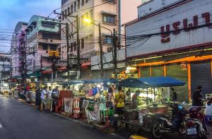 un grupo de personas de pie en un mercado al aire libre en โรงแรมไทยโฮเต็ล en Nakhon Si Thammarat