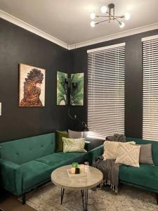 sala de estar con sofá verde y mesa en Neutral bay studio, en Sídney
