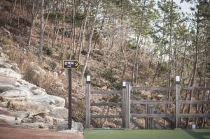 um sinal em frente a uma cerca numa montanha em Wando Oneness Resort em Wando