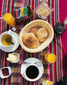 a table with a basket of bread and a cup of coffee at Wayra Hotel in Huaraz