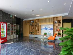 a lobby with an orange chair and a coke machine at Green Tree Inn Shandong Dongying Lijin County Phoenix Plaza in Litsinghsien