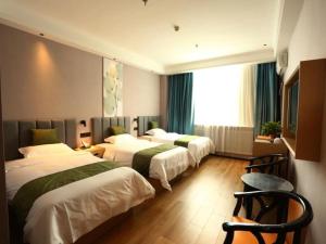 a hotel room with three beds and a window at Green Tree Inn Shandong Dongying Lijin County Phoenix Plaza in Litsinghsien