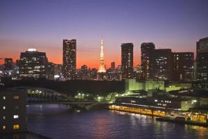 um horizonte da cidade à noite com um rio e uma ponte em Ginza Bellevue Hotel em Tóquio