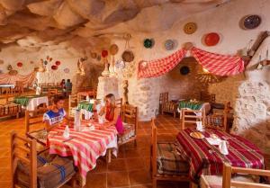 zwei Kinder, die in einem Restaurant an Tischen sitzen in der Unterkunft Welcome Meridiana in Taguermess