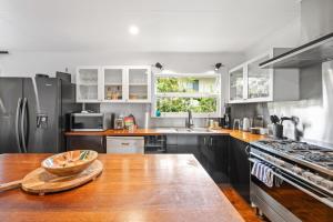 a kitchen with stainless steel appliances and a wooden table at Summer Breeze in Tewantin