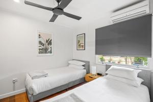 a bedroom with two beds and a ceiling fan at Summer Breeze in Tewantin