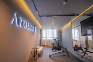 a gym with exercise equipment and a sign on the wall at Atour Hotel Tianjin Shengtaicheng Maritime Museum in Binhai