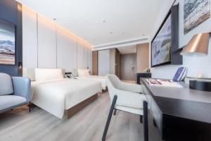 a hotel room with two beds and a desk at Atour Hotel Jinan Tangyan Dongbaqu Enterprise Park in Jinan