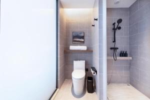 a bathroom with a white toilet in a shower at Atour Hotel Jinan Tangyan Dongbaqu Enterprise Park in Jinan