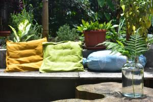 una mesa con almohadas y un jarrón con una planta en Mama's Homestay Ruteng, en Ruteng