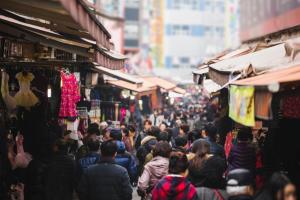 a crowd of people walking down a street in a market at 남대문시장 중심의 스타힐스호텔 in Seoul