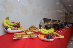 una tavola rossa ricoperta di ciotole di frutta e di alimenti di ALAZMI HOTEL a Al Khān