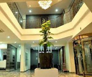 a lobby with a plant in the middle of a building at De Edge Hotel in Rumu-Ome