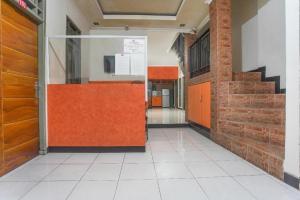 pusty korytarz z pomarańczowymi drzwiami w budynku w obiekcie SUPER OYO 3323 Icha Homestay w mieście Sudiang