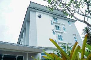 a white building with trees in front of it at BM PATTANI APARTMENT in Ban Ru Sa Mi Lae