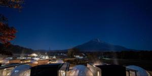 una vista su una montagna di notte con tende di VISION GLAMPING Resort & Spa Lake Yamanaka a Yamanakako