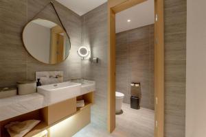 a bathroom with a sink and a mirror at Atour Hotel Urumqi Municipal Government Nanhu People's Square in Ürümqi +35 photos