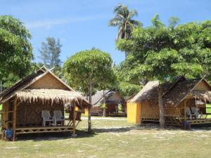 un groupe de cabanes avec chaises et arbres dans l'établissement วารินทร์ วิลเลจ, à Koh Lipe