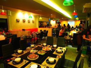un restaurante con mesas con platos de comida. en เมล่อนลอยฟ้า en Ban Kaeo