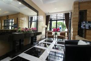 a lobby with a marble floor and chairs and windows at Arotel BSD in Tangerang