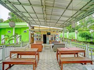 un patio con bancos y mesas en un edificio en OYO 92024 Green Hotel, en Jambi