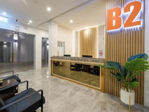 an office lobby with a large sign on the wall at B2 Map Ta Phut Boutique & Budget Hotel in Ban Huai Pong