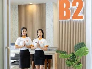 Ban Huai PongにあるB2 Map Ta Phut Boutique & Budget Hotelの手を持って二人の女