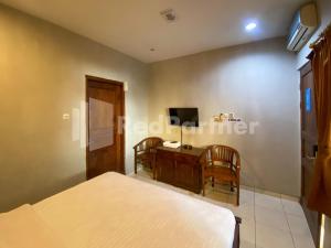 a bedroom with a bed and a desk with a computer at Istana Griya 2 Hotel Solo RedPartner in Solo