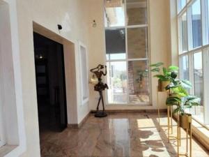 um corredor com uma câmara e algumas plantas e janelas em Easton Hill Continental Hotel em Enugu