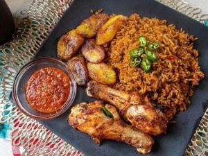 einen Teller mit Fleisch und Reis und eine Soße in der Unterkunft Easton Hill Continental Hotel in Enugu