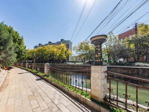 un puente sobre un río con árboles y edificios en GELI Kunming North Railway Station Zoo en Kunming