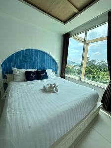 uma cama com um bicho de peluche sentado em cima dela em Costa Beach Residence & Jacuzzi em Sattahip