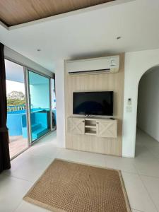 a living room with a flat screen tv on a wall at Costa Beach Residence & Jacuzzi in Sattahip