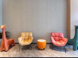 une chambre avec trois chaises de couleur différente dans l'établissement GreenTree Inn Jinan West Station Exhibition Center, à Jinan