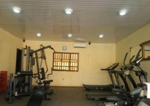 a gym with several tread machines in a room at Adap Hotel in Agbabiaka