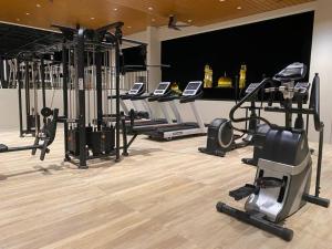 a gym with rows of exercise bikes and treadmills at J HOTEL in Kampong Kiulap
