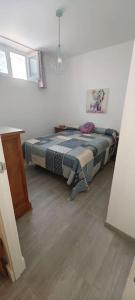 een slaapkamer met een bed in de hoek van een kamer bij Apartamento a pie de playa. in Chiclana de la Frontera
