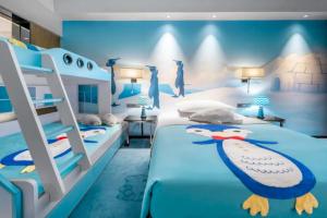 a bedroom with two beds and a penguin mural at Country Garden Phoenix Hotel Nanchong in Gaoping