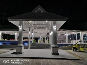 un pavillon avec une voiture garée sous celui-ci la nuit dans l'établissement Banna Resort, à Ban Na