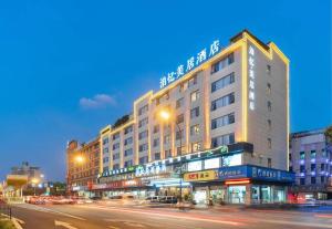 duży budynek na ulicy miejskiej w nocy w obiekcie Yiwu Bo Yi Mei Ju Hotel (International Trade Center) w mieście Liucun