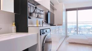 a white kitchen with a washing machine in it at Yeongjong Shine Hotel in Incheon