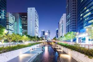 a river in the middle of a city at night at Sinchon A plus in Seoul