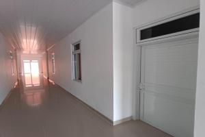 Banualuhu的住宿－OYO 92504 Guesthouse Porsea，一条带白色墙壁的走廊和车库门