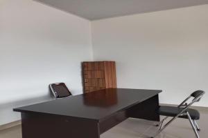OYO 92504 Guesthouse Porsea في Banualuhu: مكتب أسود مع كرسيين في الغرفة