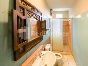 een badkamer met een toilet, een wastafel en een douche bij Istana Griya 2 Hotel Solo RedPartner in Solo