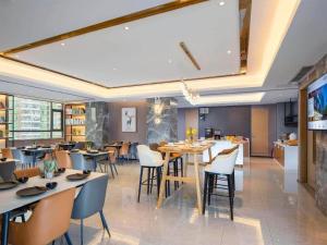 a restaurant with tables and chairs in a room at Campanile Hotel Shenzhen Guanlan Goft in Tiantangwei