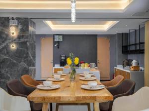 a dining room with a wooden table and chairs at Campanile Hotel Shenzhen Guanlan Goft in Tiantangwei
